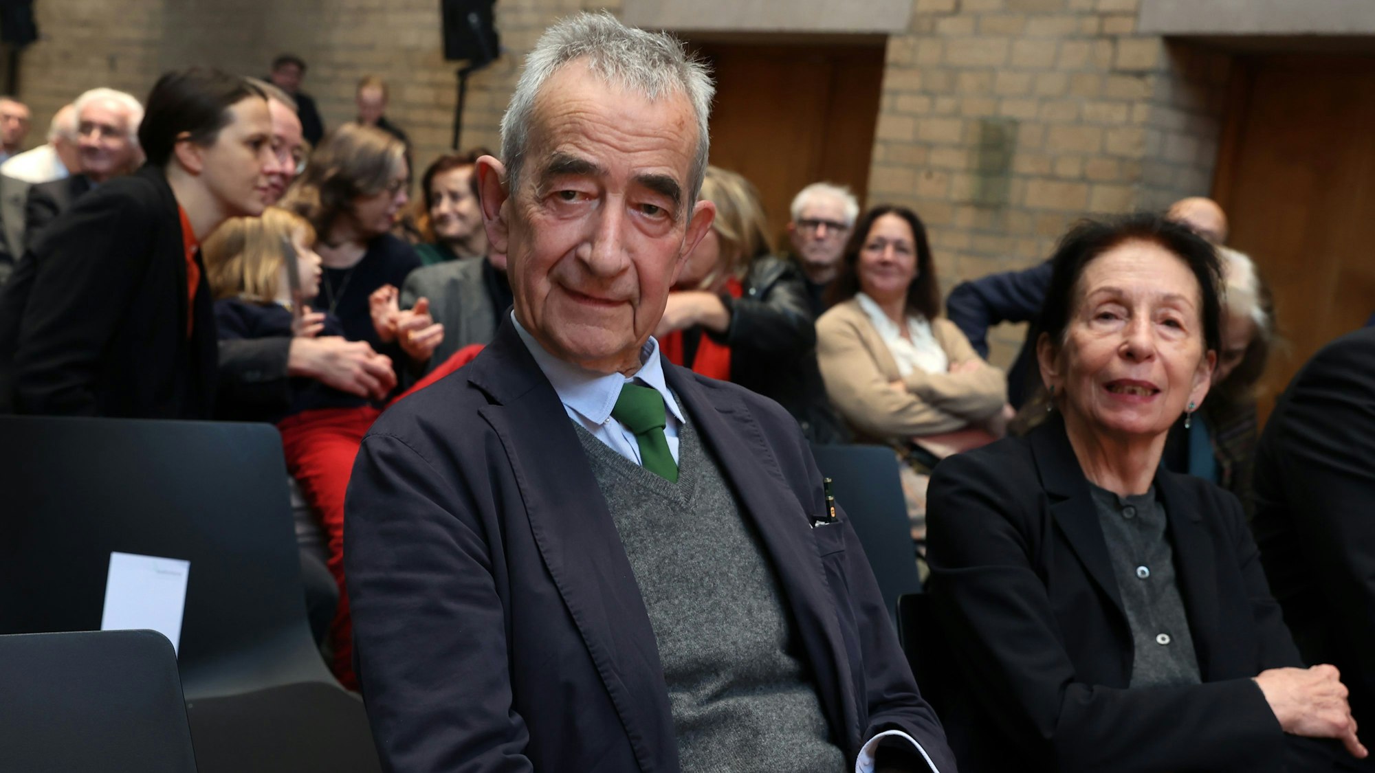 Das Foto zeigt Buchhändler und Verleger Walther König. Neben ihm sitzt eine Frau.