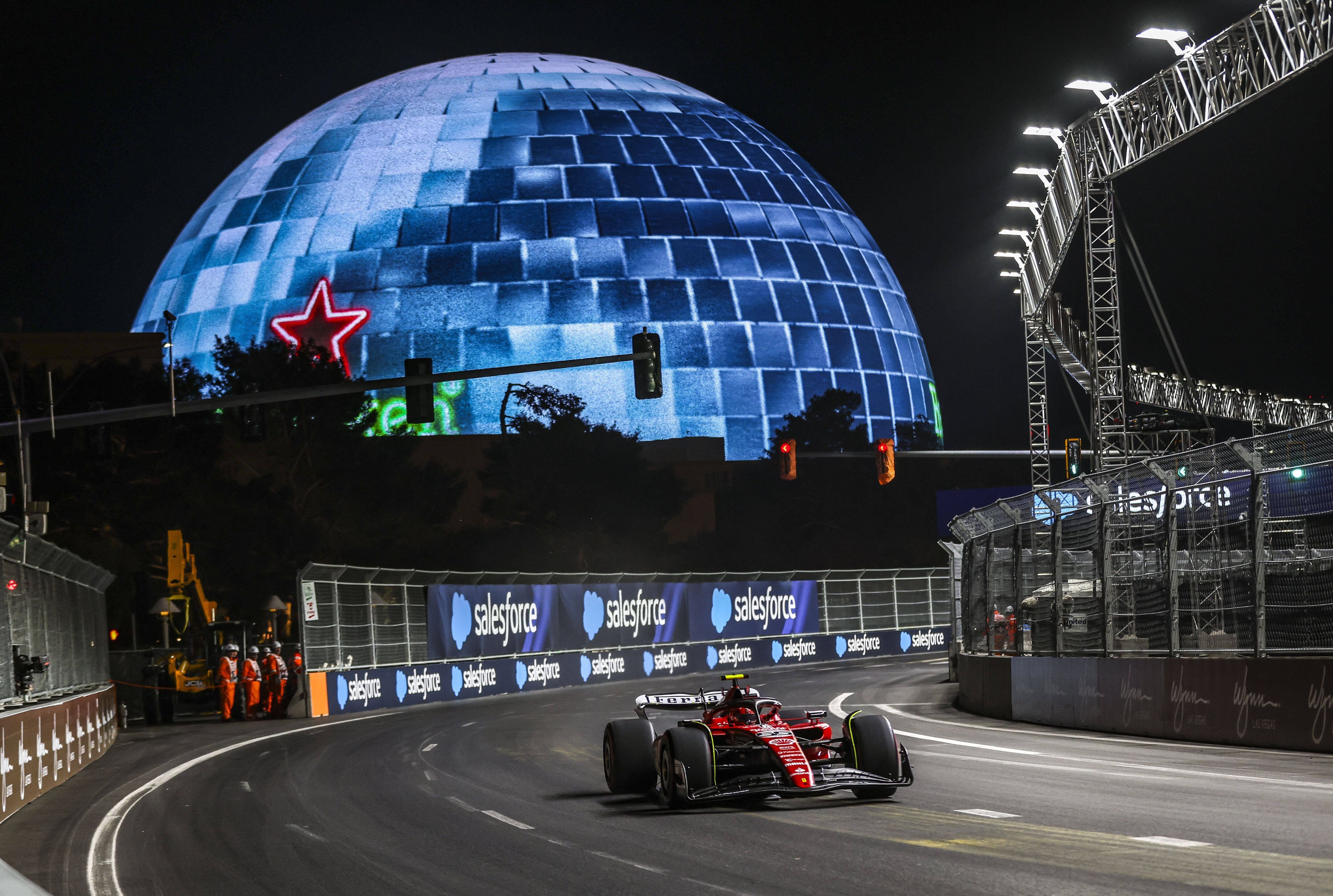 Carlos Sainz fährt mit seinem Ferrari über den Las Vegas Boulevard beim Formel-1-Rennen. Im Hintergrund ist die Las Vegas Sphere zu sehen.