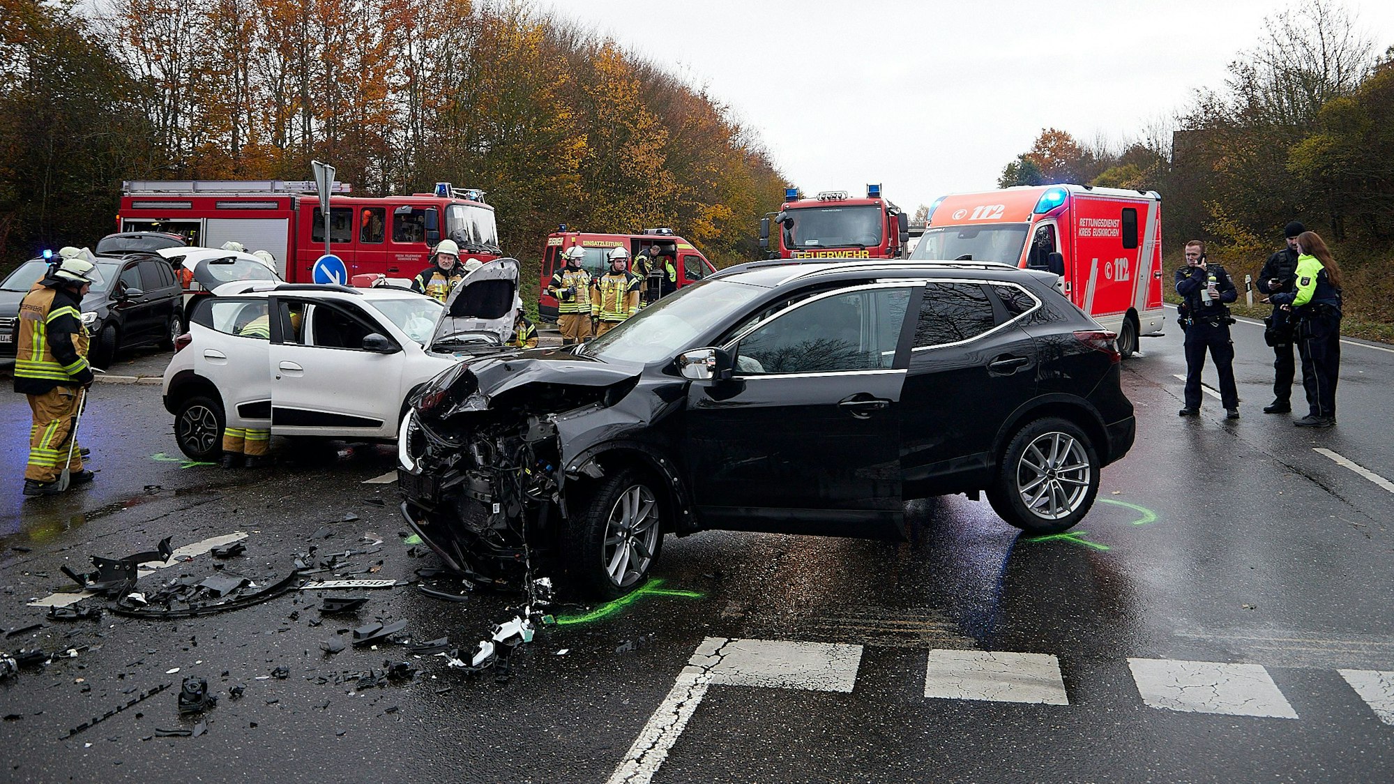 Die Unfallstelle mit den beiden zusammengestoßenen Autos. Feuerwehrfahrzeuge sichern den Kreuzungsbereich.