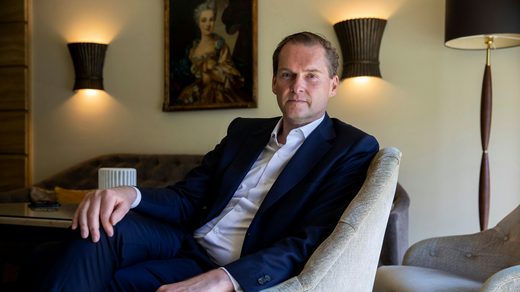 Georg Plesser, Direktor vom Excelsior Hotel Ernst, sitzt in einem Sessel