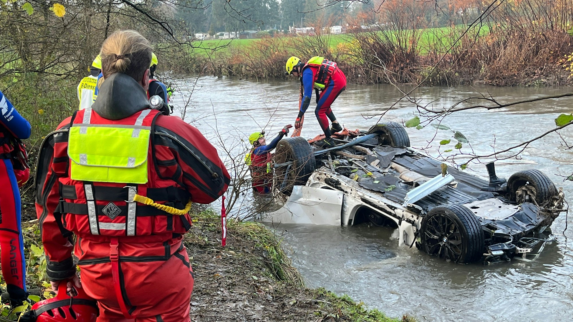 Feuerwehrleute sichern ein Auto in einem Fluss.