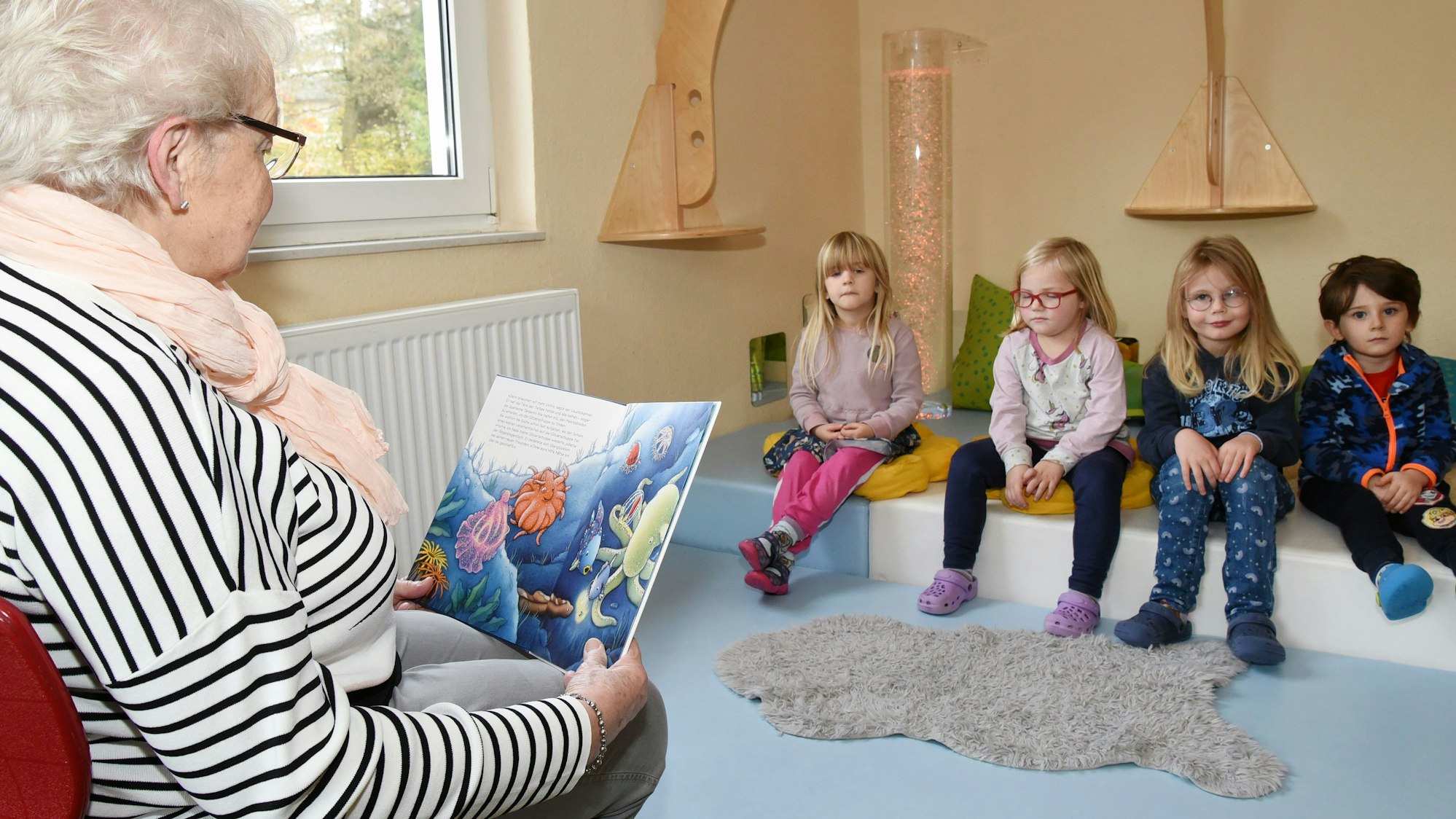 Im Wipperfürther Familienzentrum Erna Schmitz der Arbeiterwohlfahrt las auch Oma Irmhild Sieberg liest den Kindern aus dem Buch „Der Regenbogenfisch“ vor. Die Kinder lauschten gebannt den Worten der Seniorin.