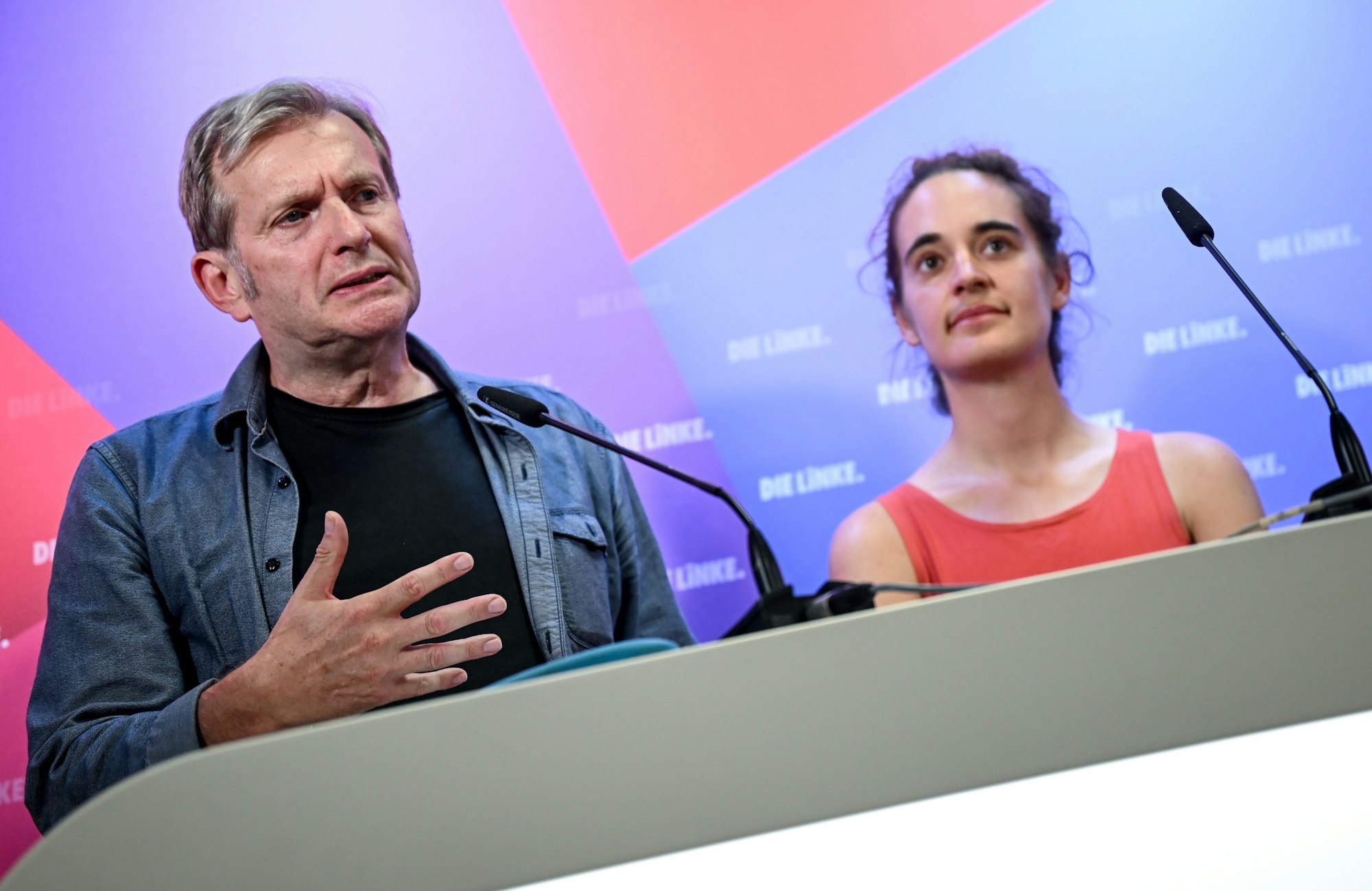 Carola Rackete,und Gerhard Trabert sprechen vor einer Werbewand.