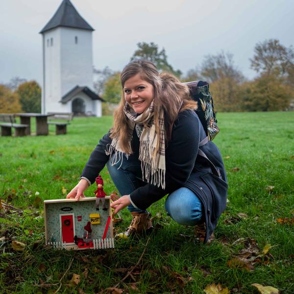 Das Bild zeigt Patricia Dreesbach vor dem Swister Turm, wie sie an einem Baum eine Wichtelwohnung aufstellt.