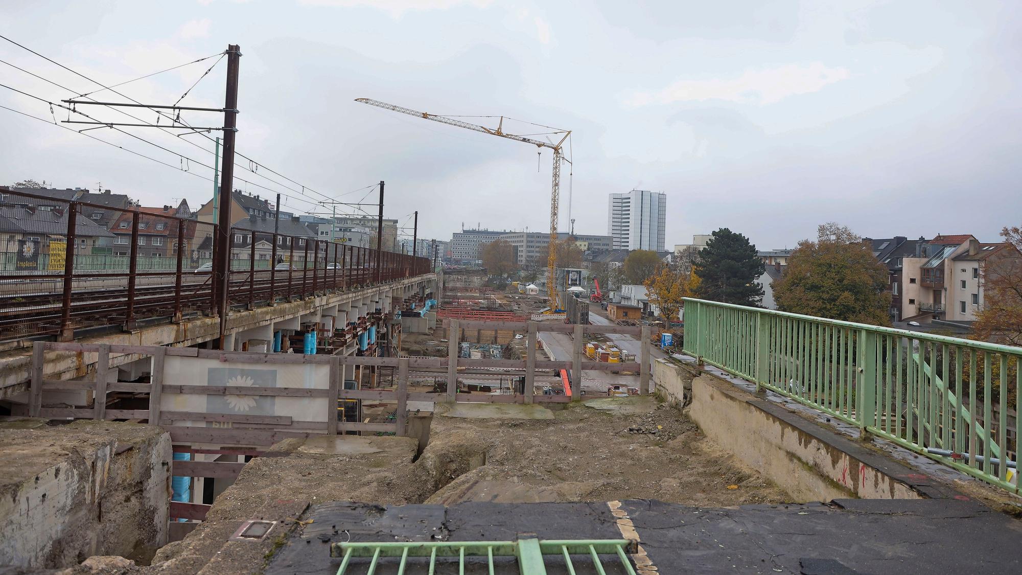 Blick auf die Baustelle, links sind Gleise der Straßenbahn mit einem Oberleitungsmast zu sehen,.