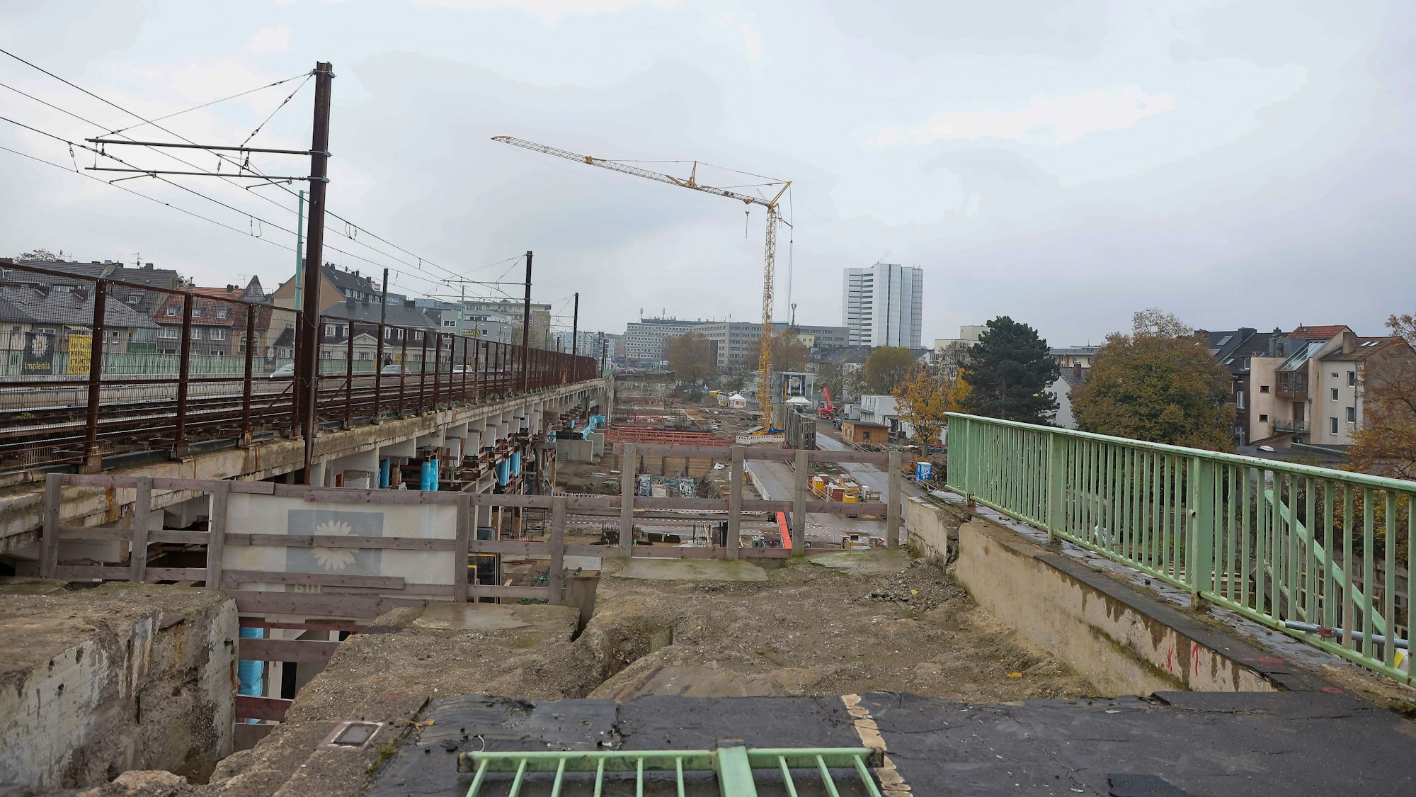 Blick auf die Baustelle, links sind Gleise der Straßenbahn mit einem Oberleitungsmast zu sehen,.