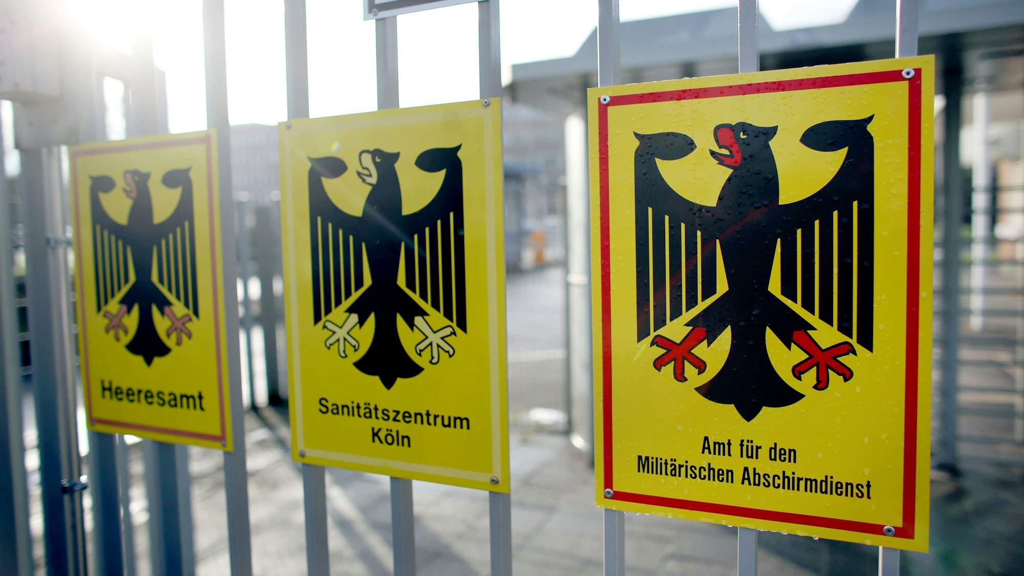 Drei Schilder mit Bundesadler an einem Zaun