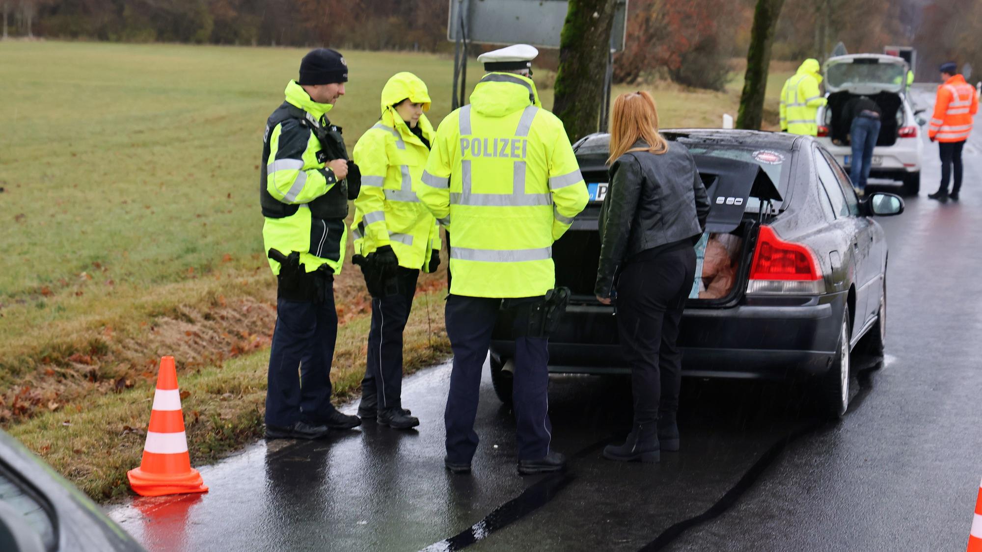 Polizeibeamte überprüfen zwei gestoppte Pkw.