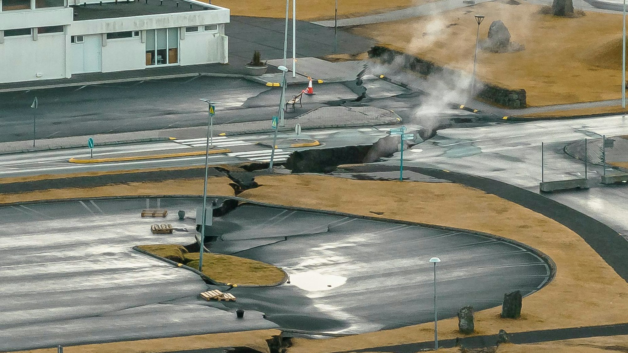 Aus Rissen im Boden neben einem Kinderspielplatz steigt in Grindavik Rauch auf Ein Ausbruch von flüssigem Gestein aus dem seit Wochen aktiven Magma-Tunnel im Südwesten Islands gilt als wahrscheinlich.