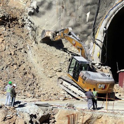 18.11.2023, Indien, Uttarakhand: Ein Bagger arbeitet am Eingang eines im Bau befindlichen Straßentunnels, der eingestürzt ist. Die Bohrarbeiten zur Rettung von etwa 40 Arbeitern in einem eingestürzten Autobahntunnel im Norden Indiens sind vorübergehend unterbrochen worden. Ein eigens aus der Hauptstadt Neu Delhi eingeflogenes Bohrgerät habe am Freitagnachmittag (17.11.2023) seine Arbeit eingestellt, nachdem ein lautes Knacken im Tunnel zu hören gewesen sei, berichtete die Nachrichtenagentur PTI am Samstag unter Verweis auf Behörden. Das Geräusch habe Panik bei den Rettungskräften ausgelöst. Foto: ---/AP/dpa +++ dpa-Bildfunk +++