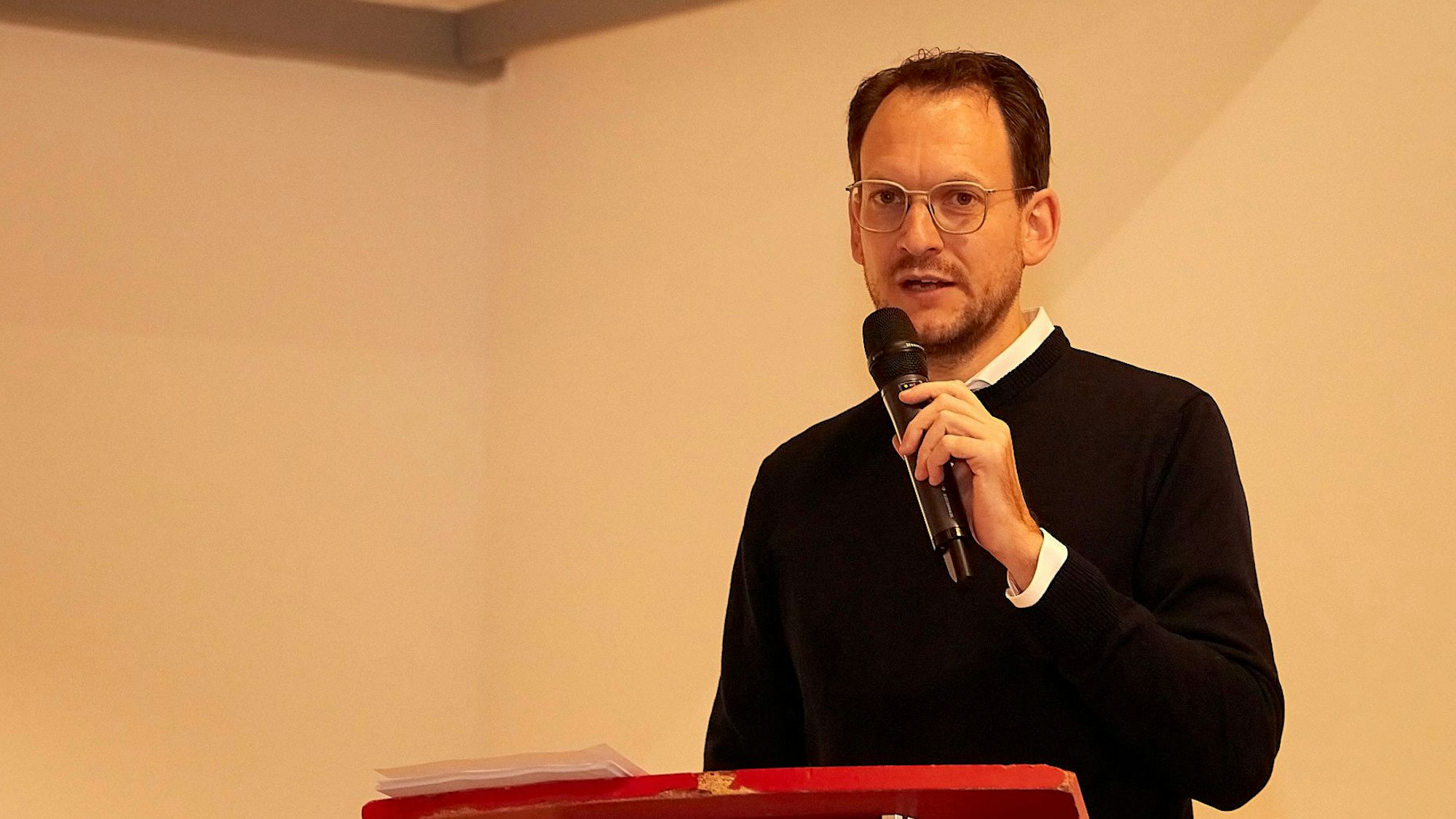 Thilo Waasem spricht beim Kreisparteitag und hält ein Mikrofon in der Hand.