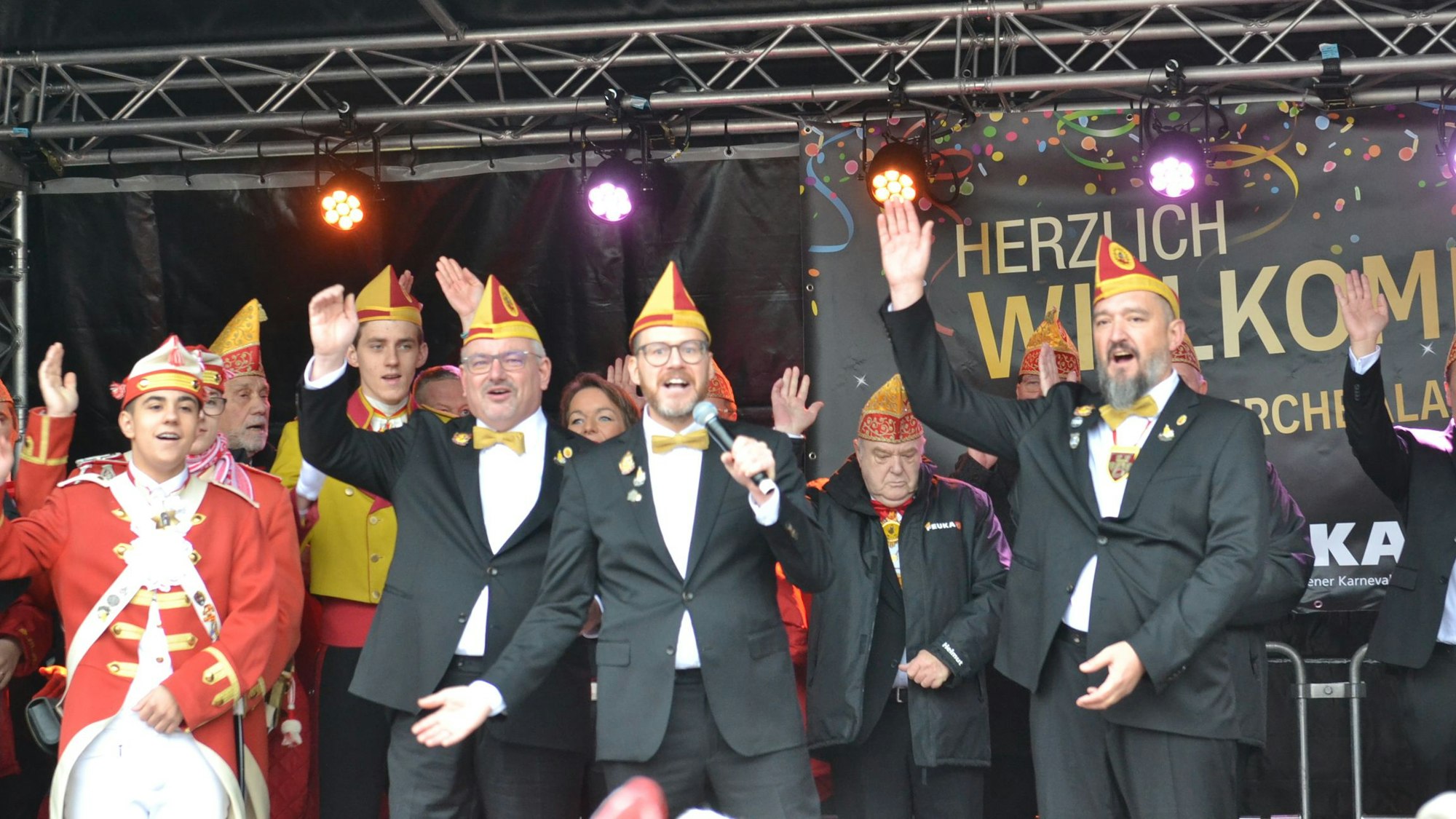 Die designierten Euskirchener Tollitäten Riccardo Mota Ramos (v.l.), Martin Niessen, Tobias Wiesen und Sascha Kremp stehen auf der Bühne, im Hintergrund weitere Karnevalisten.