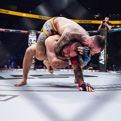 Zwei Männer ringen im Oktagon.