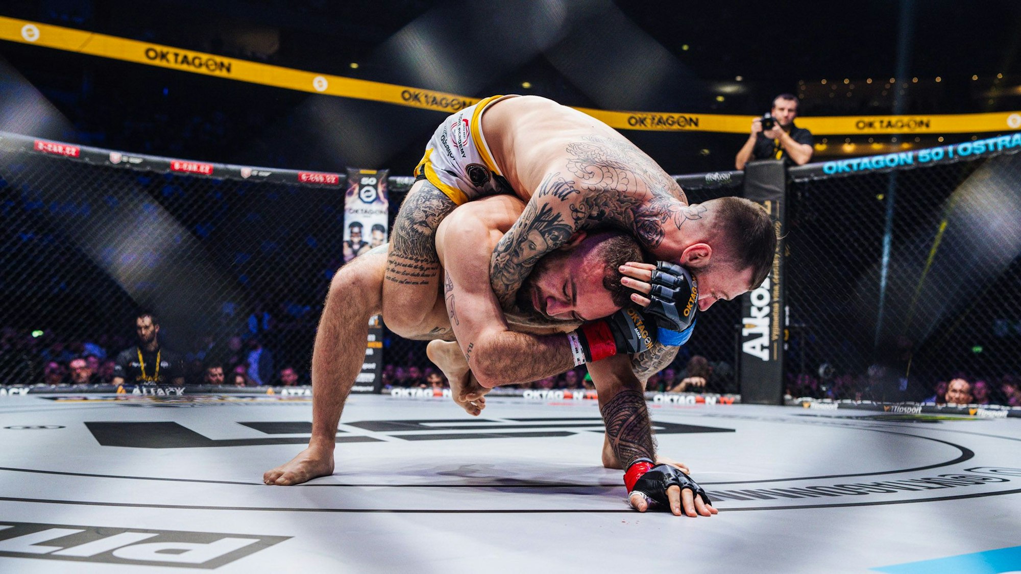 Zwei Männer ringen im Oktagon.