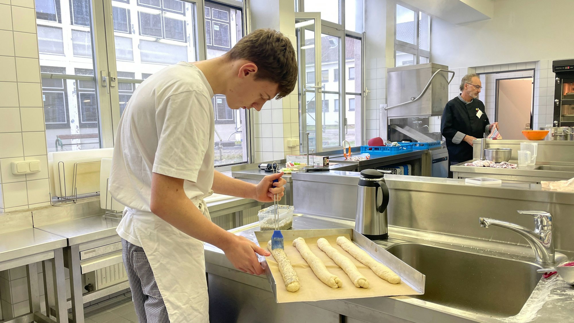 Das Foto zeigt Azubi David in der Lehrbackstube des Berufskollegs.