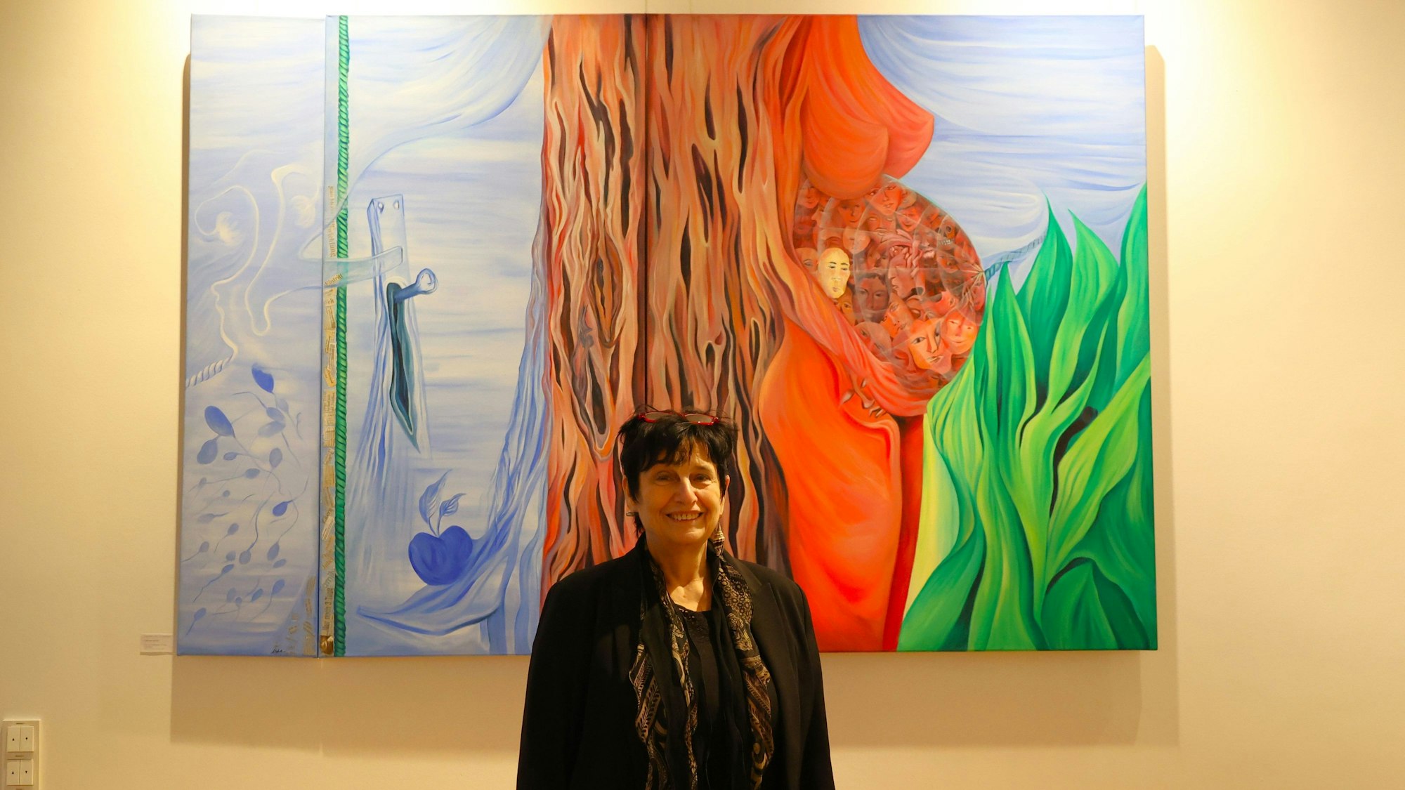 Ellen Loh-Bachmann vor ihrer Arbeit „Zufall der Geburt, Triptychon“ in der Friedenskirche, Schlebusch