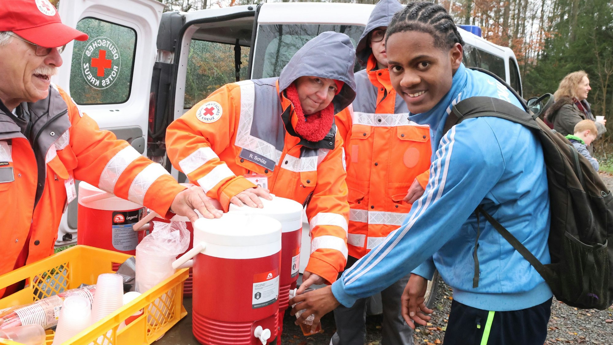 Ein junger Mann bekommt einen Becher Tee.