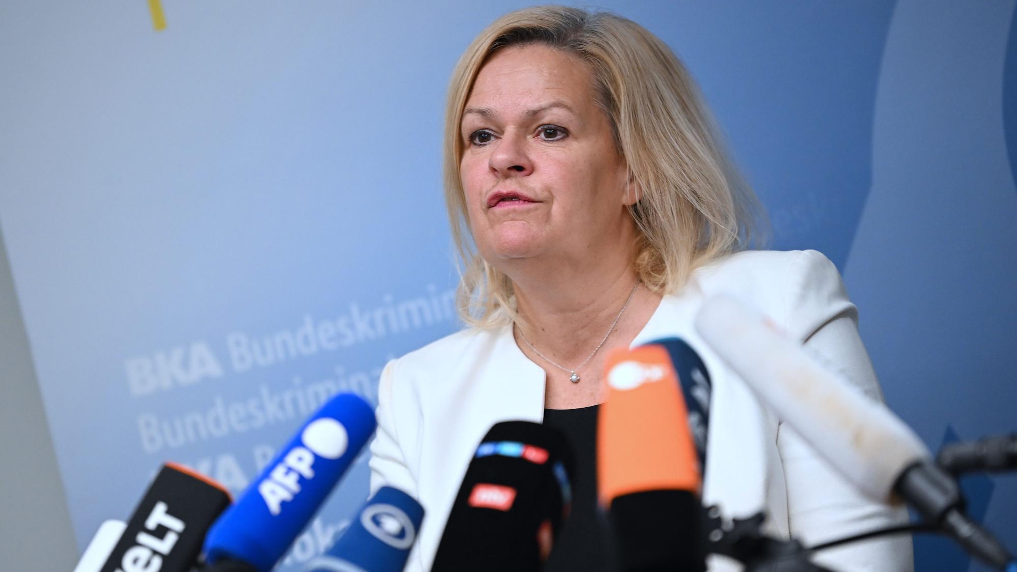Nancy Faeser steht hinter Mikrofonen und beantwortet Fragen.