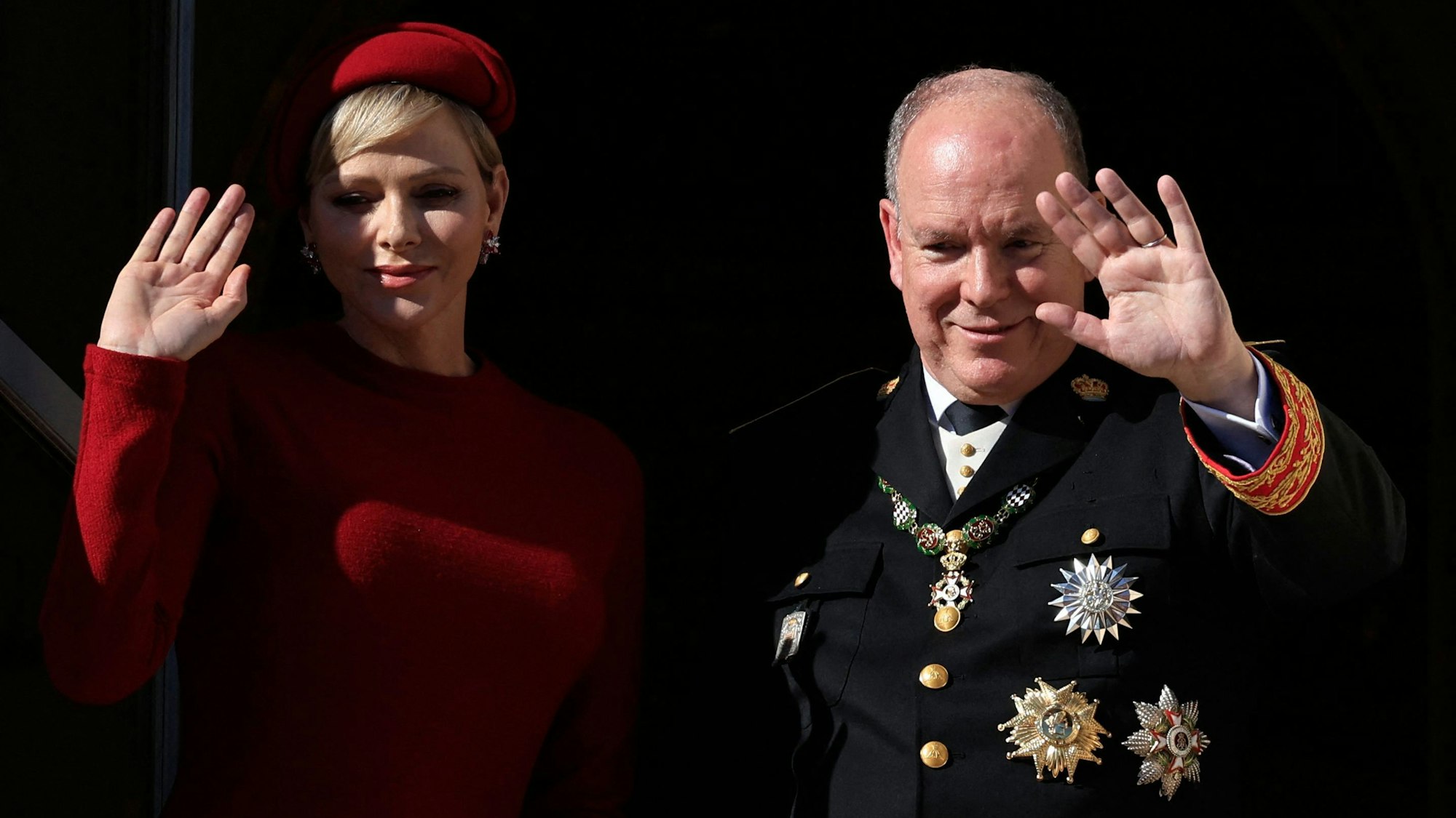 Fürst Albert II. von Monaco (r.) und Fürstin Charlène von Monaco (l.) winken vom Balkon des Fürstenpalastes während einer Zeremonie zum Nationalfeiertag.