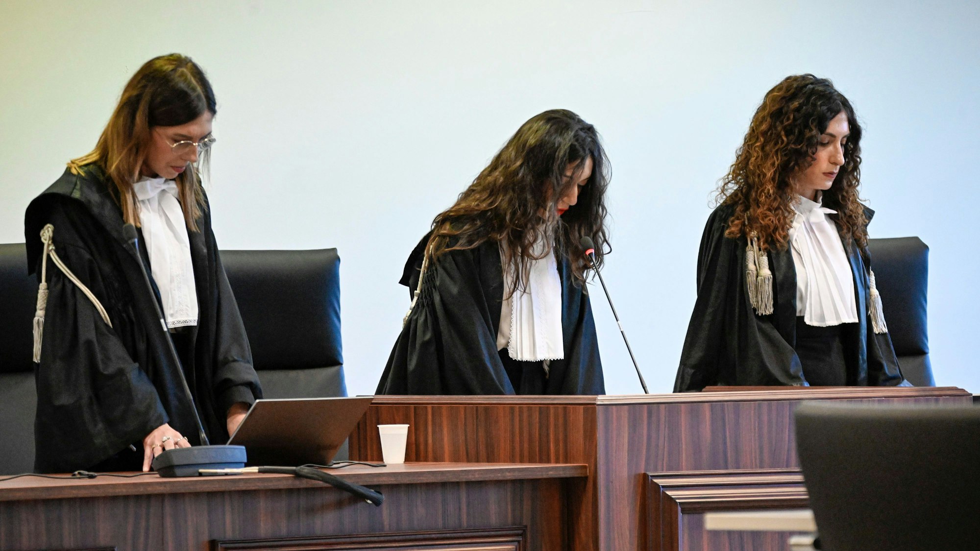 Richterinnen erheben sich zur Verlesung des Urteils.