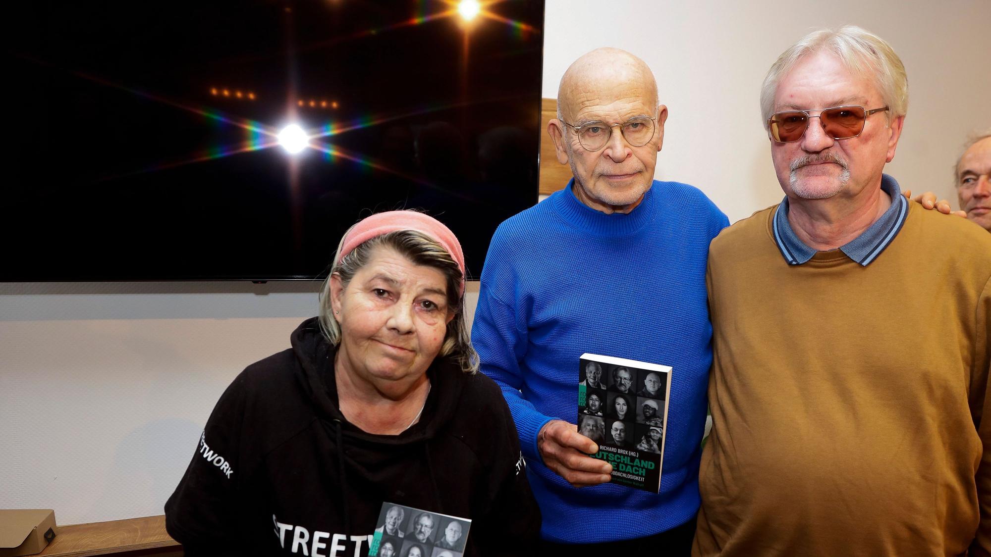 Linda Rennings, Günther Wallraff und Richard Brox bei der Buchvorstellung „Die Neue Obdachlosigkeit“, Rennings und Wallraff haben ein Buch in der Hand.
