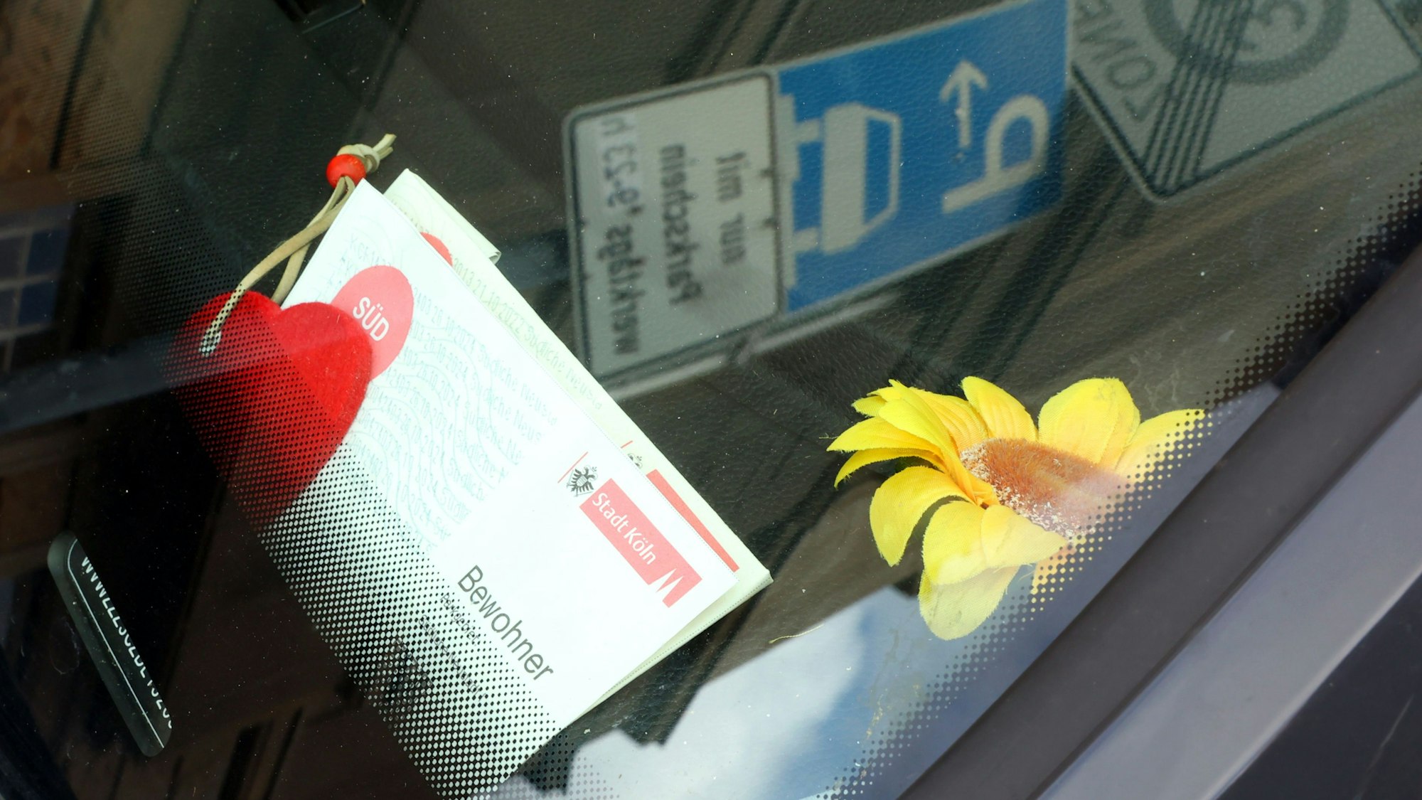 Ein Bewohnerparkausweis liegt hinter einer Scheibe.