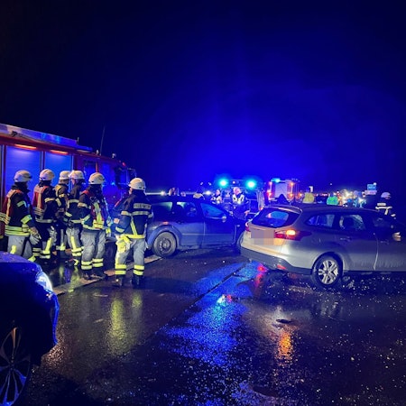 Das Bild zeigt Feuerwehrkräfte und beschädigte Fahrzeuge auf der Autobahn.