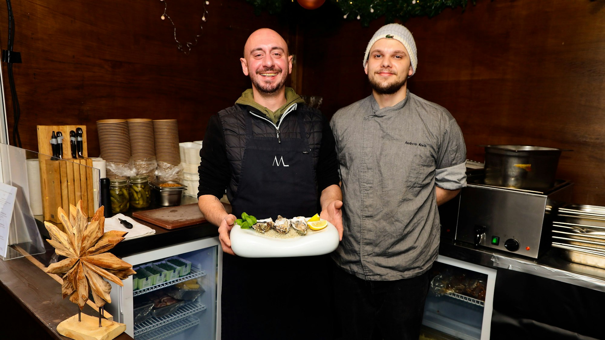 Zwei Mitarbeiter präsentieren Austern am Stand von Sterne-Koch Maximilian Lorenz.