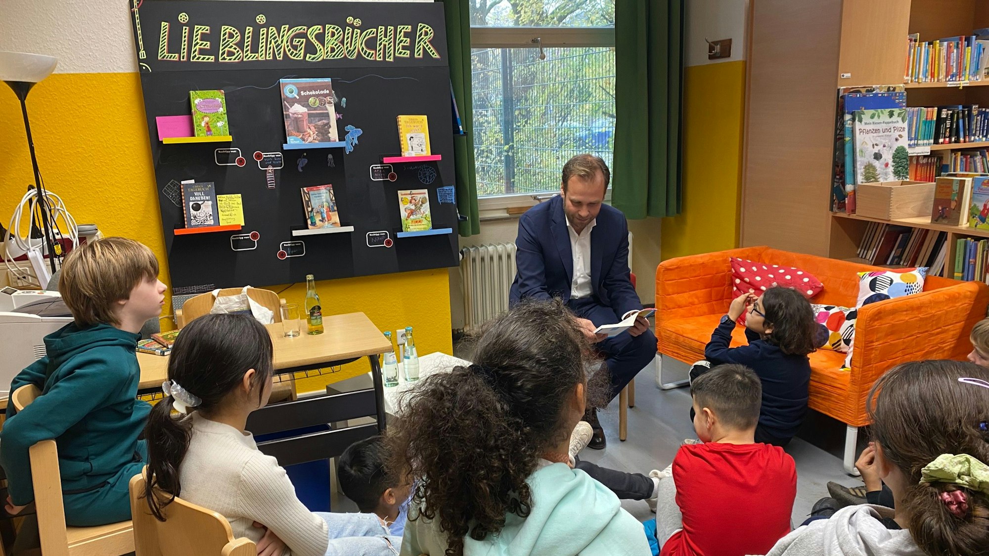 Zu sehen ist Robert Voigtsberger, Beigeordneter für Bildung der Stadt Köln. Er liest aus dem Kinderbuch „Mein Freund Salim“ von Uticha Marmon vor.