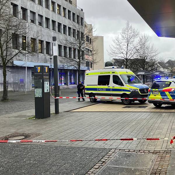 Zwei Polizeiautos stehen auf einer Fußgängerzone. Es ist Absperrband zu sehen.