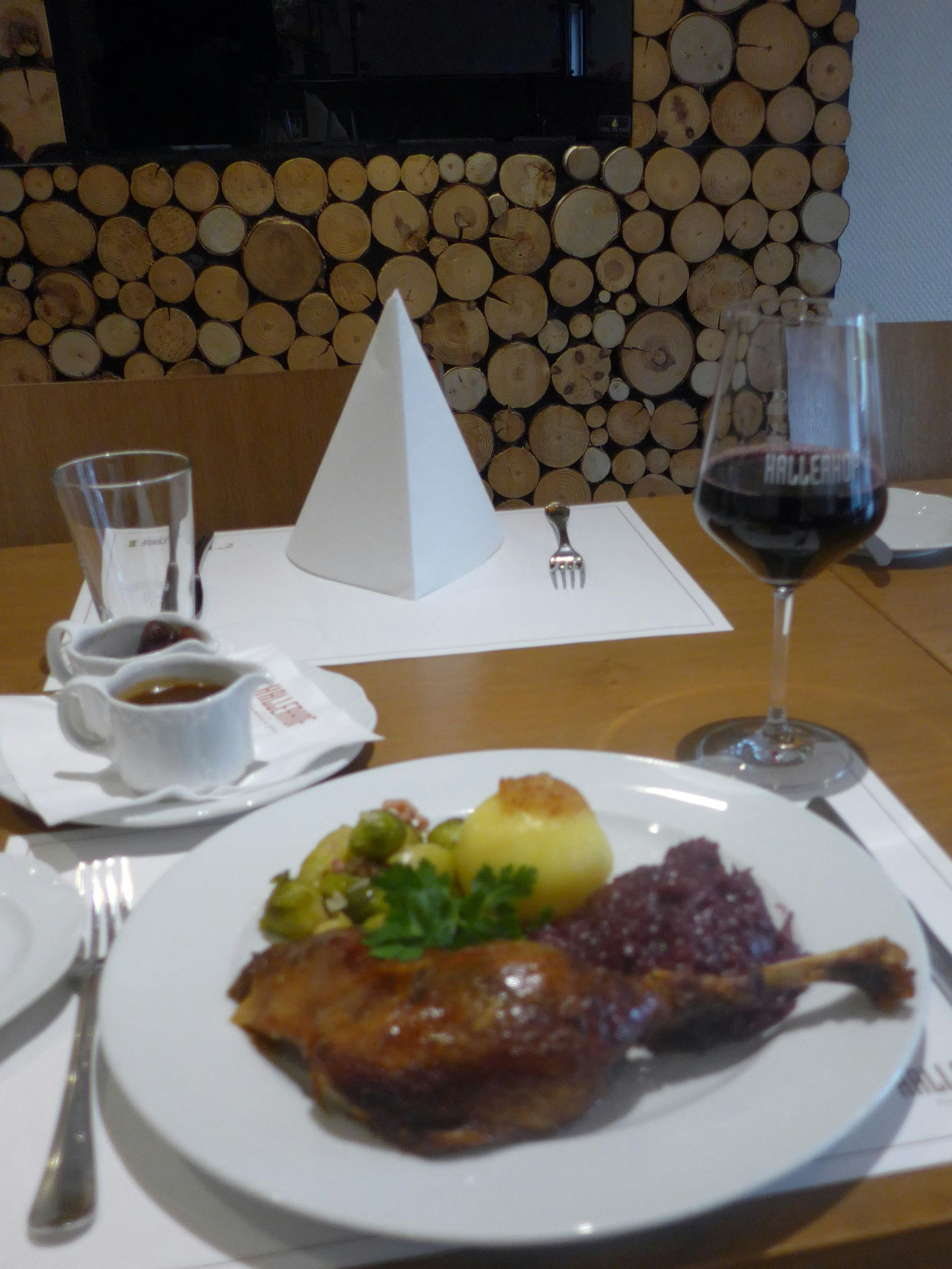 Das Bild zeigt einen gedeckten Tisch mit Gans und einem Glas Rotwein.