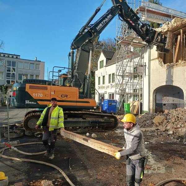 Mit einem Bagger wird ein altes Haus abgerissen