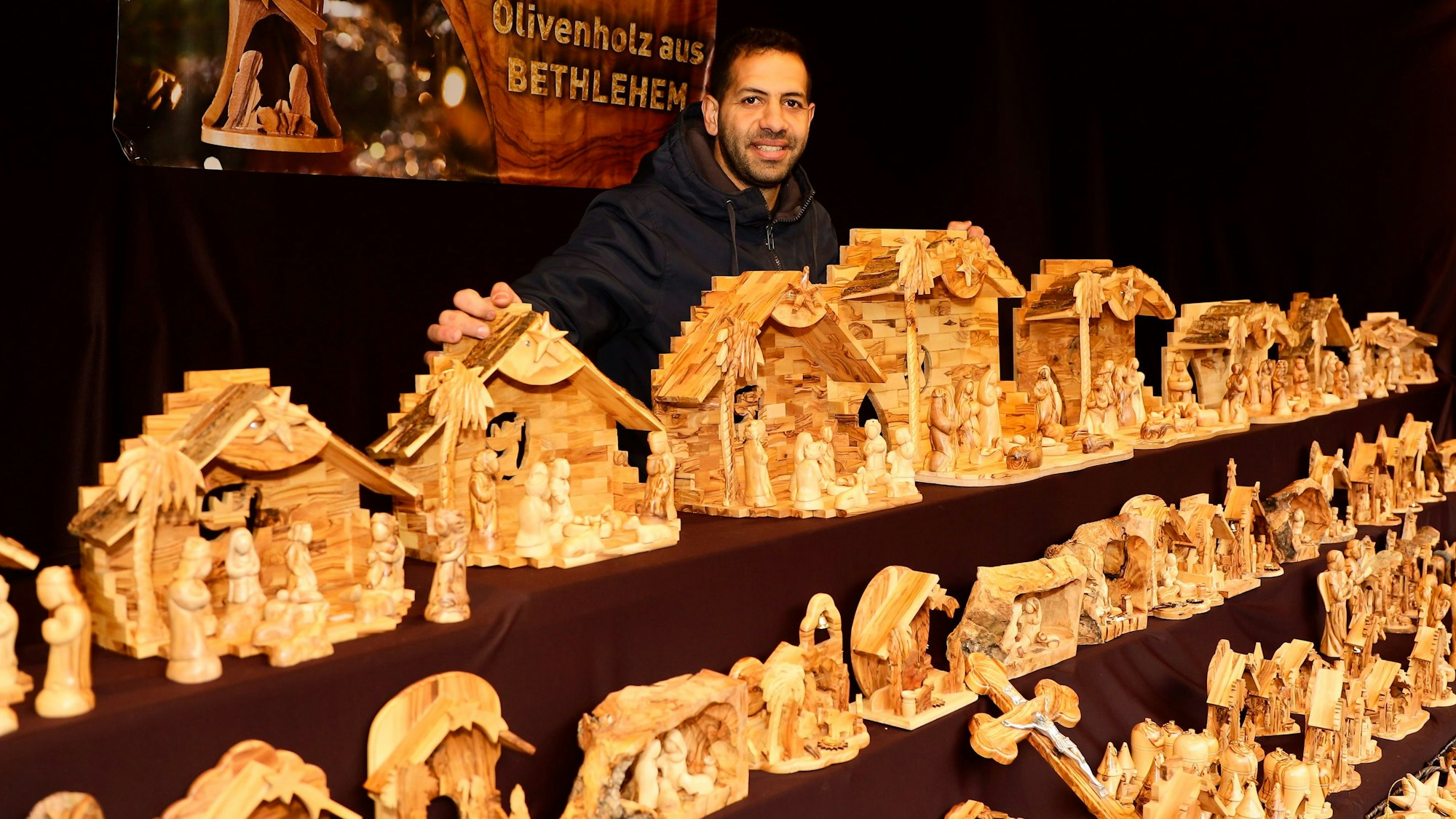 Ibrahim Kattan posiert hinter Holzkrippen.