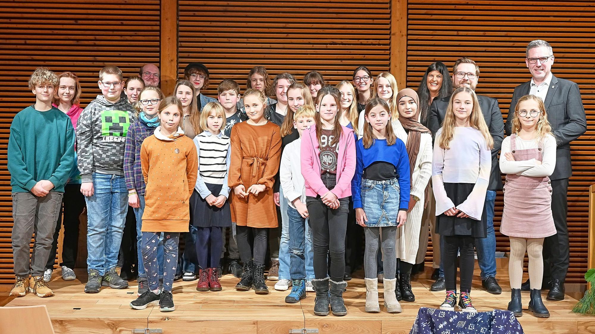 Das Foto zeigt Jurymitglieder und Preisträger des Eifeler Jugendliteraturpreises 2023 auf der Bühne des Holzkompetenzzentrums in Nettersheim.