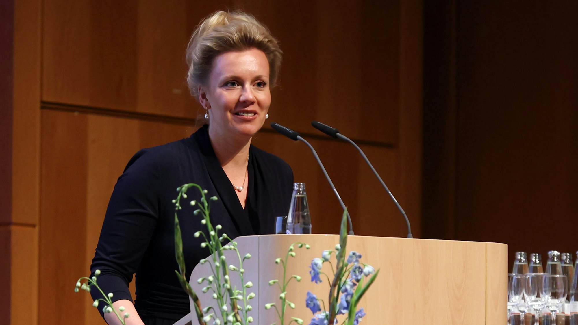 Ina Brandes, Ministerin für Kultur und Wissenschaft, steht in der Universität zu Köln an einem Rednerpult.