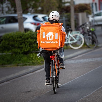 Ein Fahrer des Lieferdienstes Lieferando.de von hinten auf der Straße