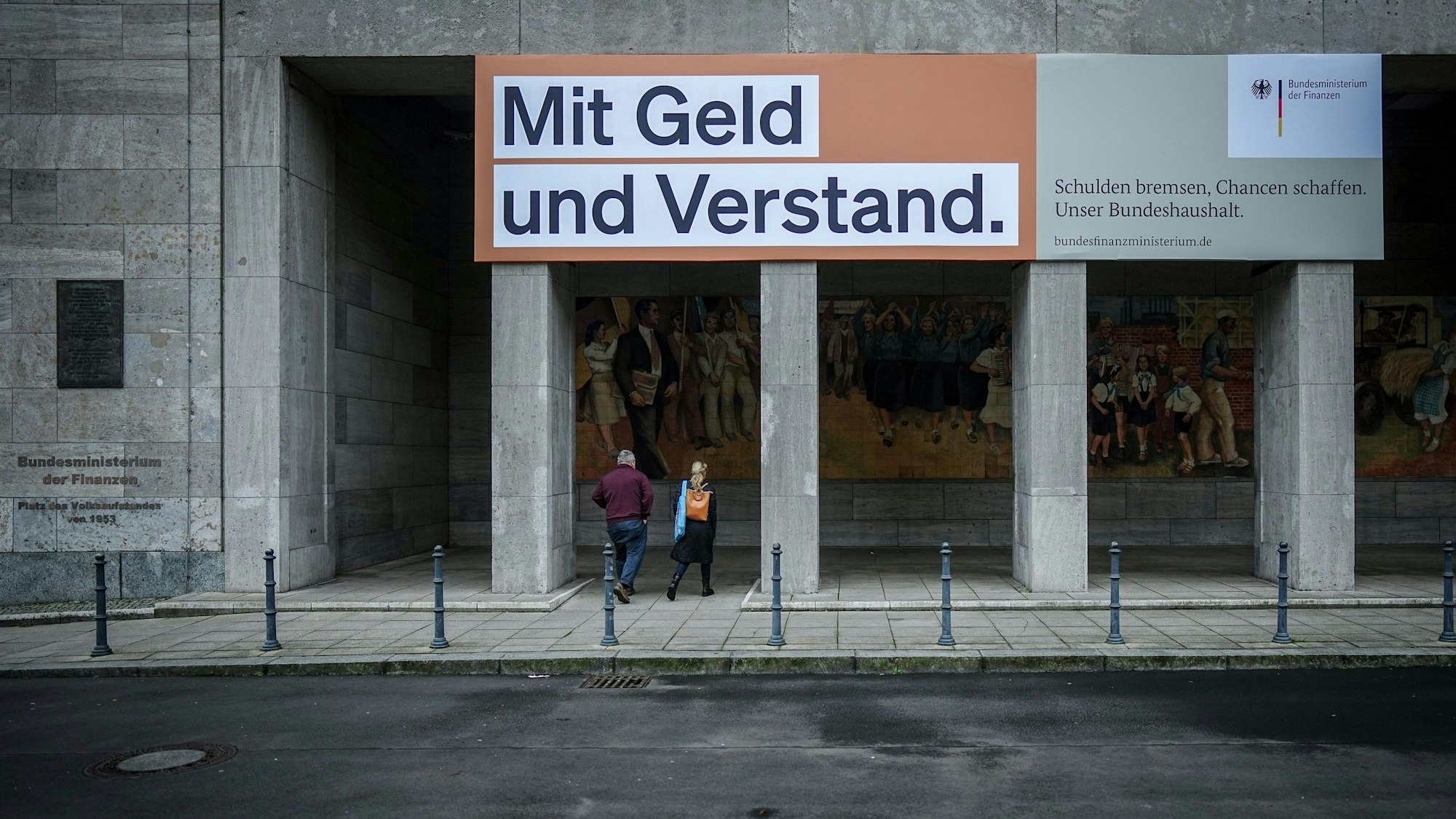 Ein Plakat mit der Aufschrift „Mit Geld und Verstand. Schulden bremsen, Chancen schaffen. Unser Bundeshaushalt.“ hängt über dem Eingang zum Bundesministerium der Finanzen.