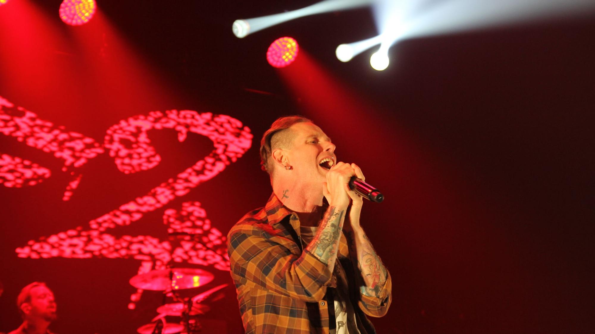 Der Sänger Corey Taylor trat in Köln auf. Im Hintergrund sind Lichteffekte zu sehen.