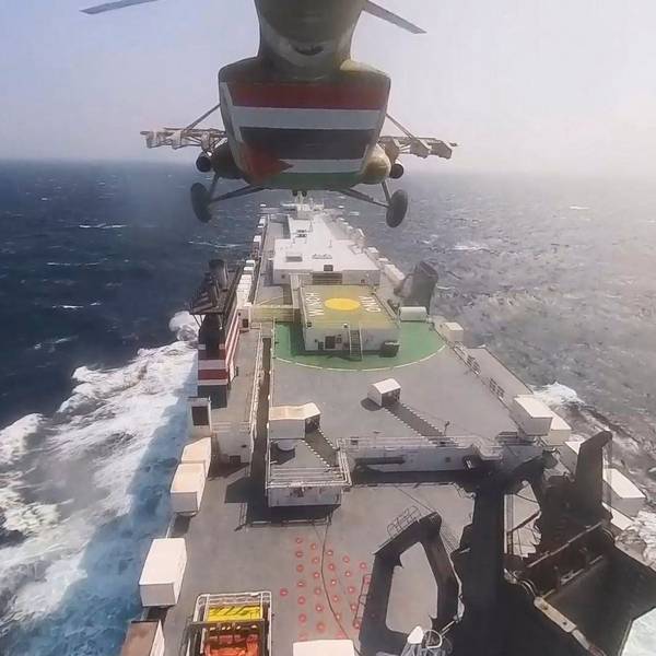 This photo released by the Houthi Media Center shows a Houthi forces helicopter approaching the cargo ship Galaxy Leader on Sunday, Nov. 19, 2023. Yemen's Houthis have seized the ship in the Red Sea off the coast of Yemen after threatening to seize all vessels owned by Israeli companies. (Houthi Media Center via AP)
