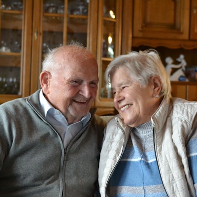 Lächelnd halten sich die beiden Eheleute im Arm.