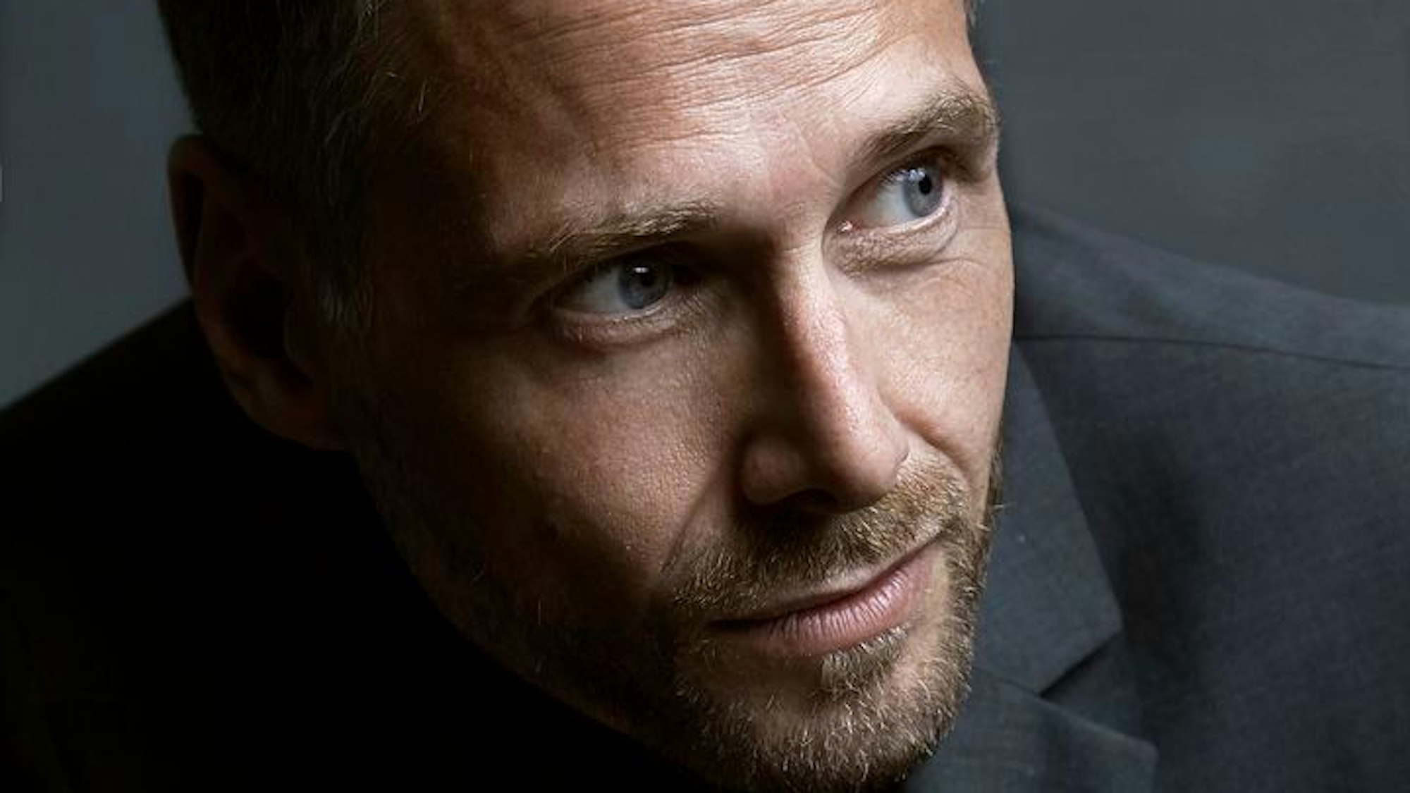 Eine Nahaufnahme des Sängers Michael Nagy. Er hat einen braunen Bart und blaue Augen.