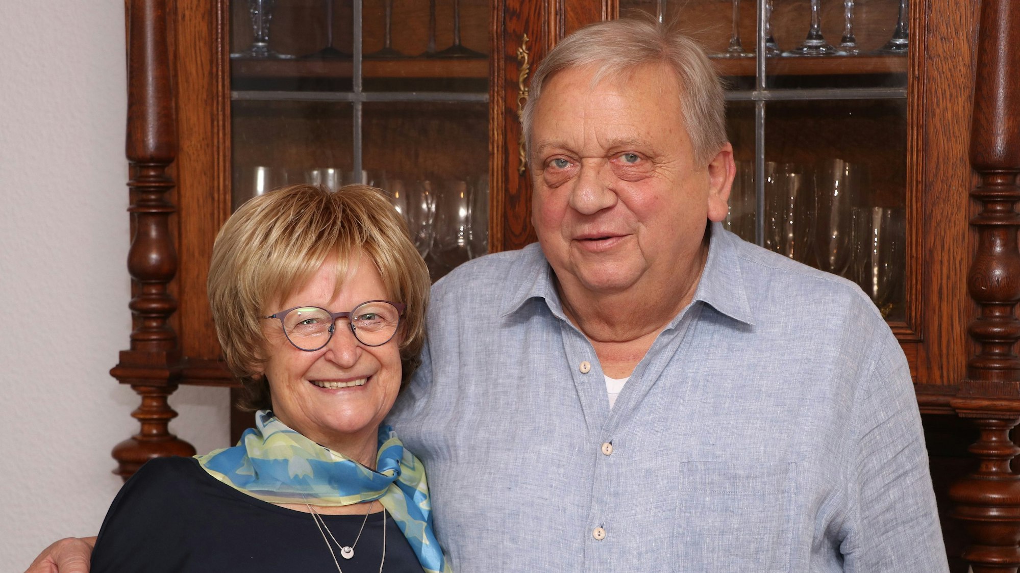 Ein Ehepaar vor einem rustikalen Schrank.