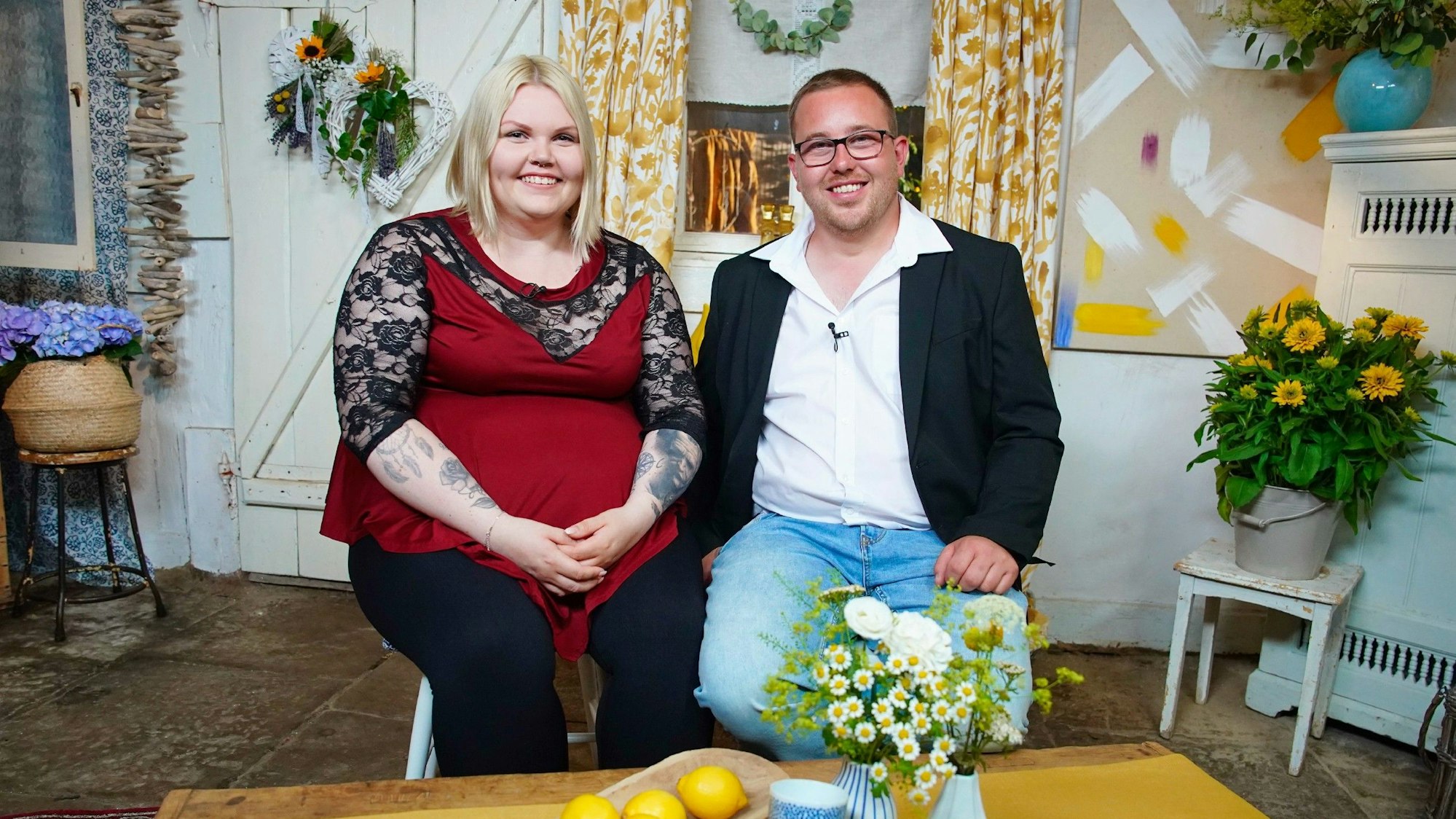 Bauer Stephan und Kandidatin Lisa sitzen nebeneinander und lächeln in die Kamera.