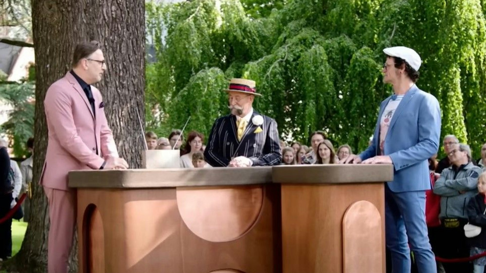 ZDF-Moderator Horst Lichter (Mitte) spricht mit „Bares für Rares“-Experte Detlev Kümmel (links) und Bieter Jörg F. (rechts) über die ungewöhnliche Skulptur.