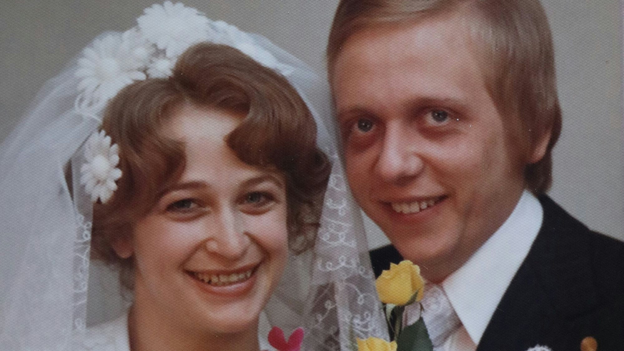 Ein altes Foto einer Braut mit Schleier und eines Bräutigams im Anzug.