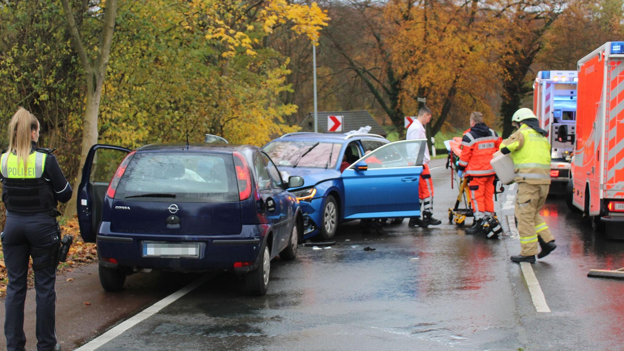 Zwei Unfallautos stehen auf einer Straße. Rettungsdienst, Feuerwehr und Polizei kümmern sich um die Verletzten und die Unfallaufnahme.