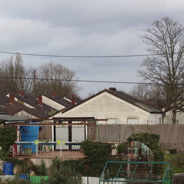Blick auf verwahrloste Häuser mit ehemals weißen Fassaden.