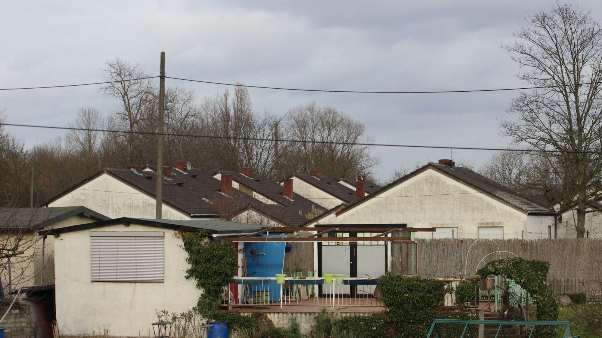 Blick auf verwahrloste Häuser mit ehemals weißen Fassaden.