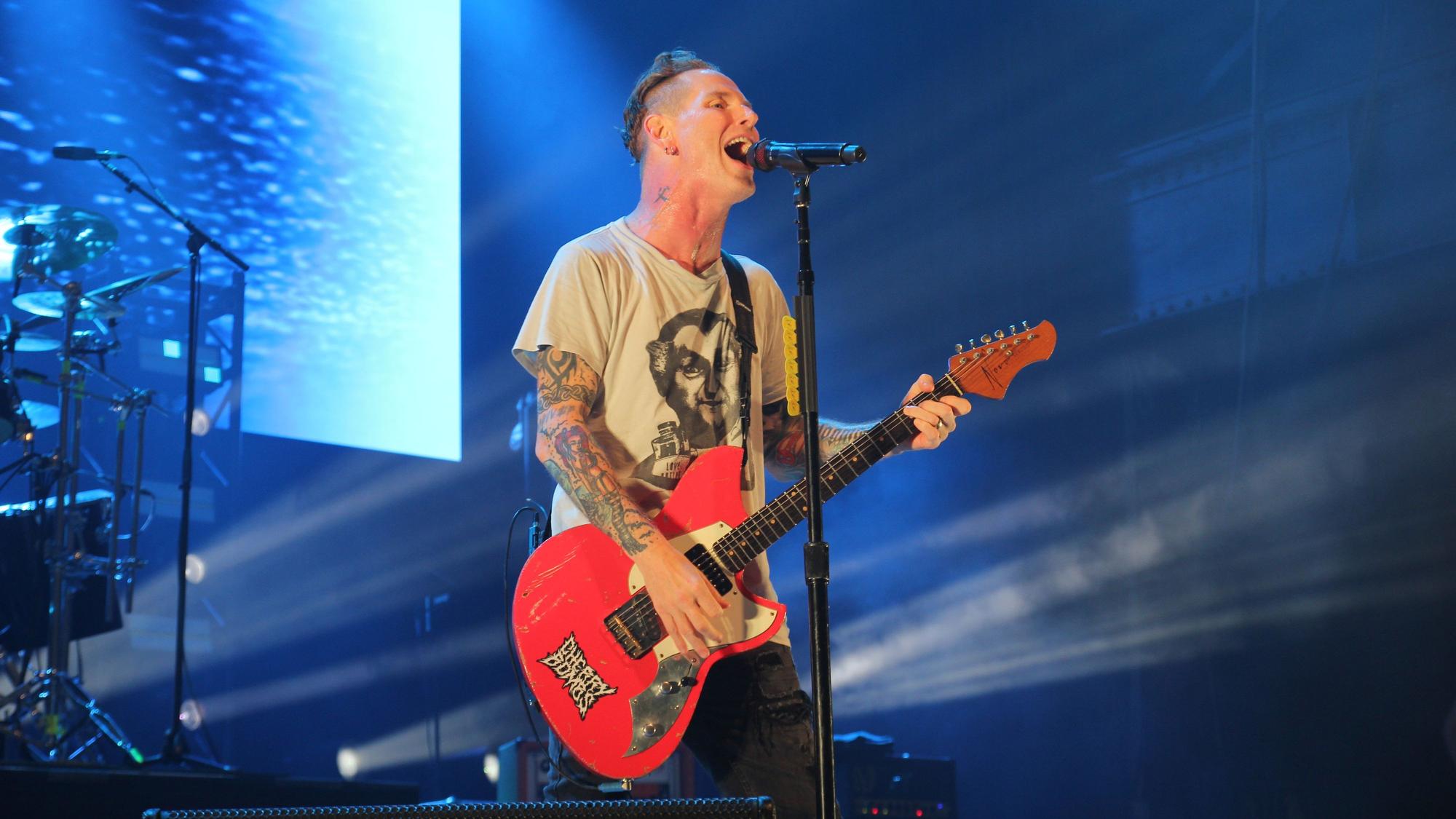 Sänger Corey Taylor hat sich eine rote Gitarre umgeschnallt.