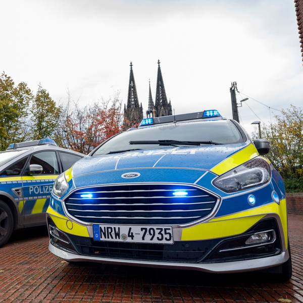 Das Foto zeigt zwei Polizeiwagen vor dem Kölner Dom.